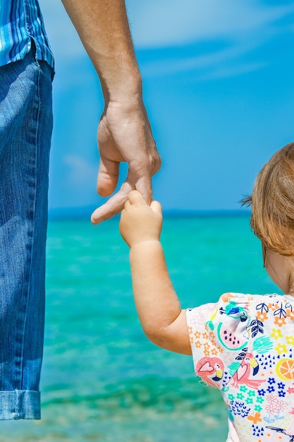 Mains d'heureux parent et enfant en mer fond de Grèce