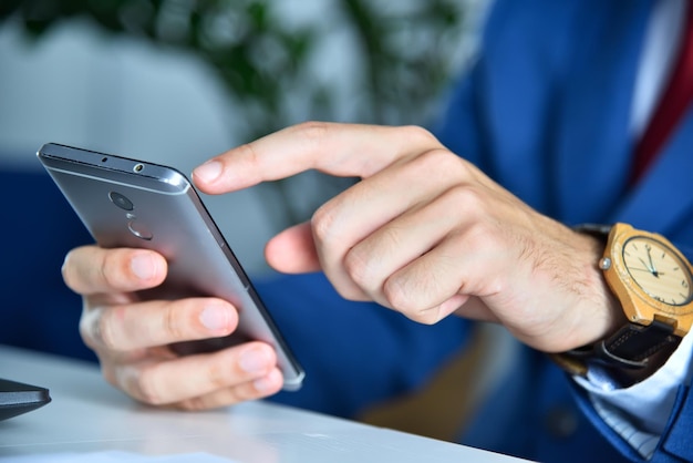 Mains d'homme d'affaires à l'aide de téléphone intelligent