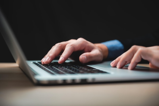 Mains d'homme d'affaires tapant sur le clavier de l'ordinateur agrandi bannière homme d'affaires ou étudiant utilisant un ordinateur portable à la maison apprentissage en ligne marketing internet travaillant à partir du bureau à domicile indépendant