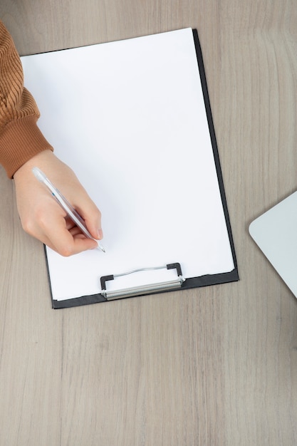 Mains d'homme d'affaires travaillant en prenant des notes sur le bureau.