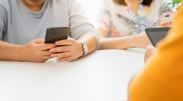 Mains d'homme à l'aide d'un smartphone à la table