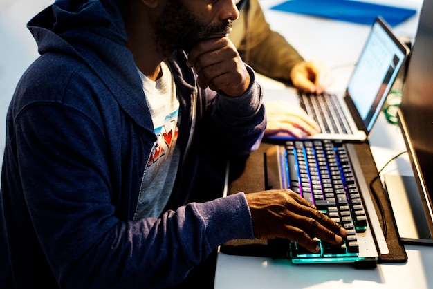 Photo mains d'homme d'ascendance africaine travaillant sur un clavier d'ordinateur