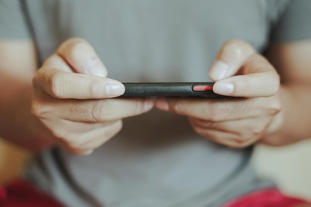 Photo les mains d'un homme asiatique jouant à un jeu sur smartphone