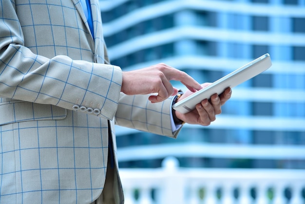 Mains d'homme commerçant à l'aide d'un ordinateur tablette numérique