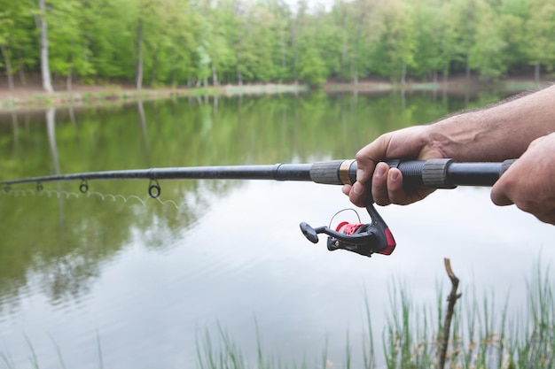 Les mains d'un homme dans un plan Urp tiennent une canne à pêche