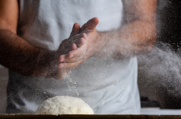 Mains d'homme, farine et pâte.