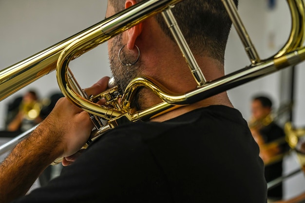 Les mains de l'homme jouant du trombone dans l'orchestre