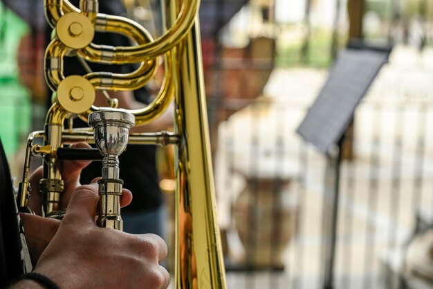 Les mains de l'homme jouant du trombone dans l'orchestre