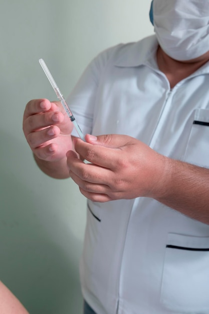 les mains d'un homme latin tenant une seringue et un liquide médicinal à injecter comme vaccin