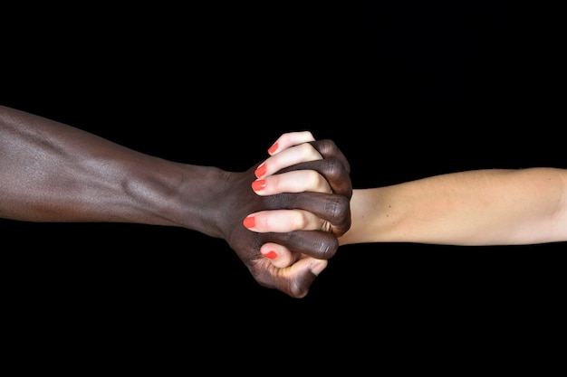 Une mains d&#39;homme noir et femme blanche sur fond noir