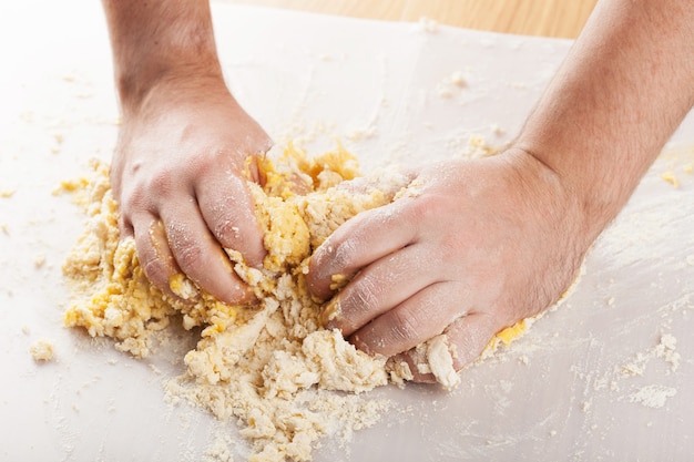 Mains d'homme pétrir une pâte