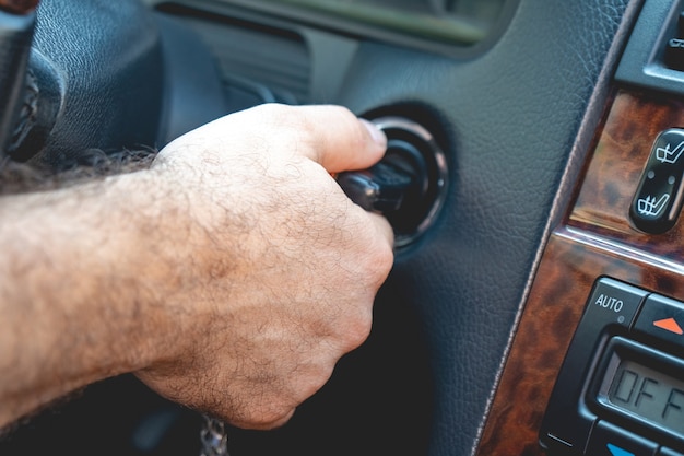 Les mains de l'homme pour prendre les clés pour démarrer la voiture à moteur.