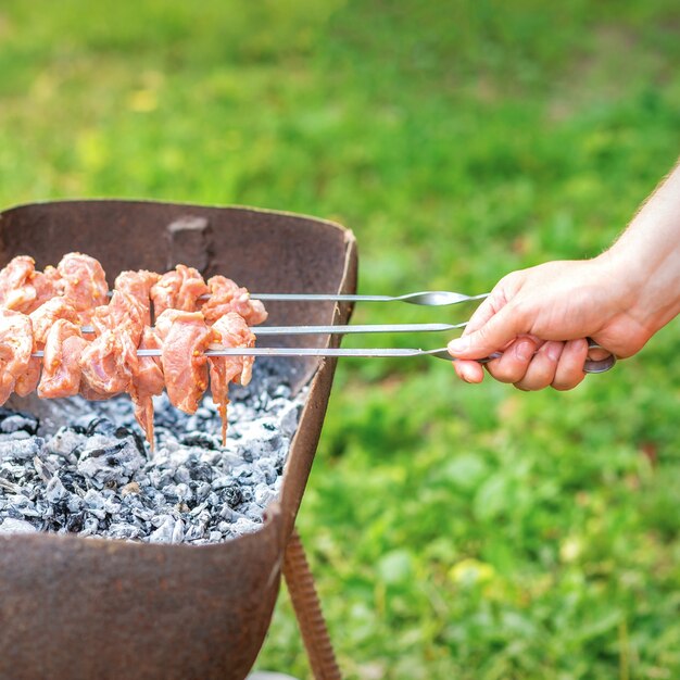 Les mains de l'homme préparent la viande de barbecue