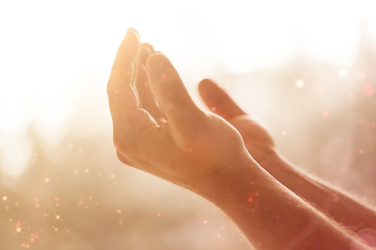 Photo mains de l'homme priant sur fond de bokeh croisé