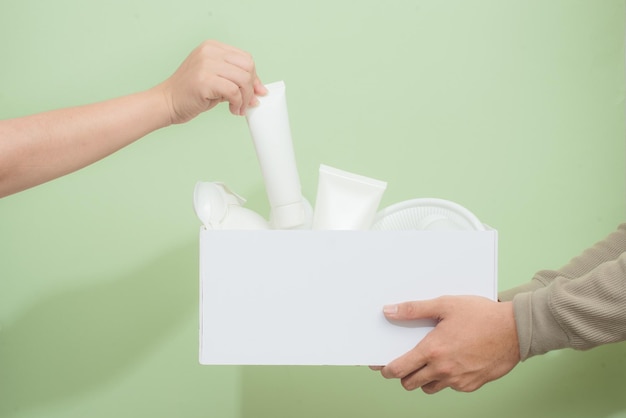 Les mains de l'homme tenant un carton avec des ordures en plastique pour le recyclage Concept de recyclage