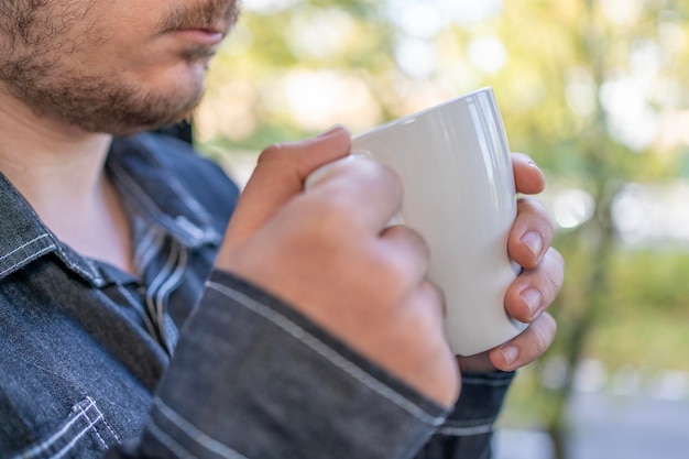 Mains d'homme tenant une tasse de café