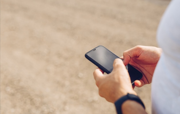 Mains de l'homme touchant l'écran du téléphone.