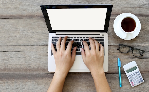 Les mains des hommes d&#39;affaires travaillent sur le clavier de l&#39;ordinateur portable et d&#39;autres équipements connexes placés à proximité.