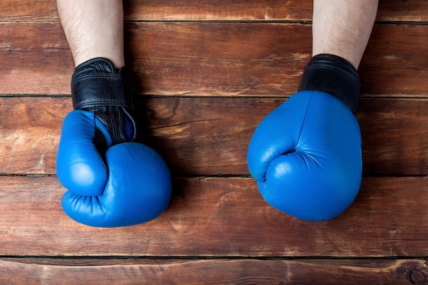 Les mains des hommes dans des gants de boxe sur un fond en bois. Geste prêt. concept d'entraînement pour l'entraînement de boxe ou de combat.