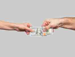 Photo les mains des hommes et des femmes gardent des dollars sur un fond gris concept d'investissements donations de charité