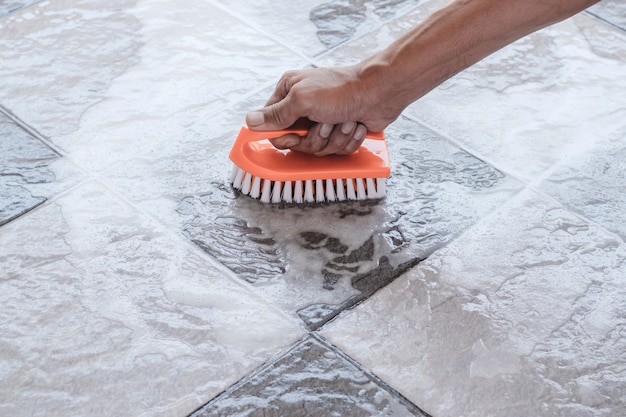 Les mains des hommes sont utilisées pour convertir le nettoyage de polissage sur le carrelage.