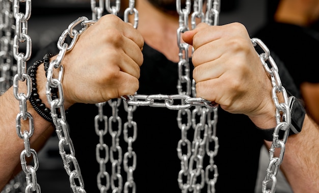 Les mains des hommes tentent de briser le test de la chaîne pour la force. photo de haute qualité