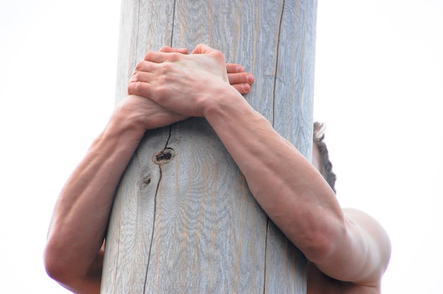 Les mains des hommes tiennent au poteau sur blanc