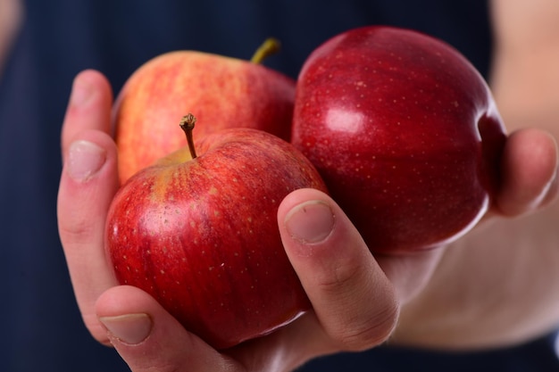 Les mains des hommes tiennent des pommes rouges Pommes de couleur juteuse fraîche