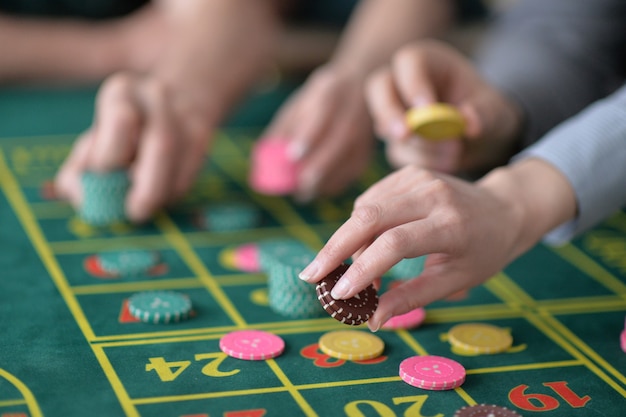 Des mains humaines jouant avec des jetons de casino se bouchent