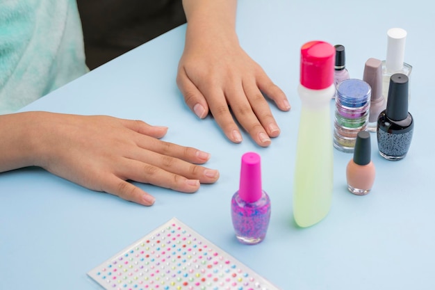 Mains d'une jeune femme latine qui va peindre ses ongles avec des vernis et des accessoires