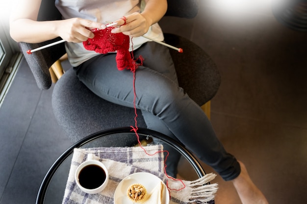 les mains de la jeune femme à tricoter des chandails chauds