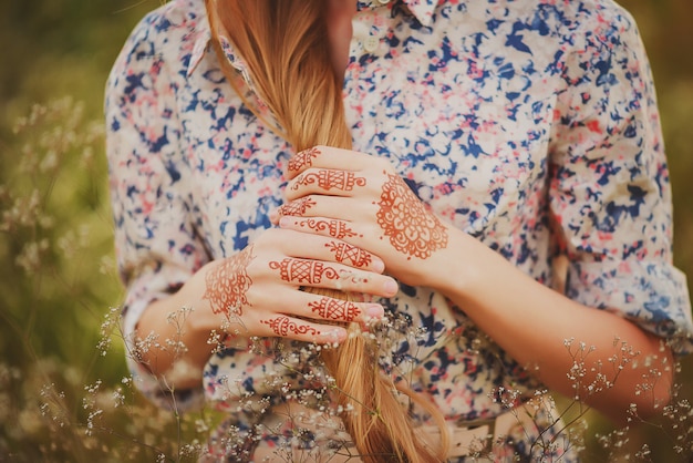 Mains d'une jeune fille avec des dessins de mehendi dans le style boho. Mise au point sélective douce.