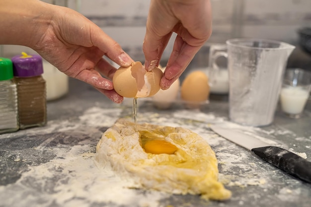 Mains d'une jeune fille préparant la pâte pour les boulettes de pommes de terre Le concept de cuisine par une femme