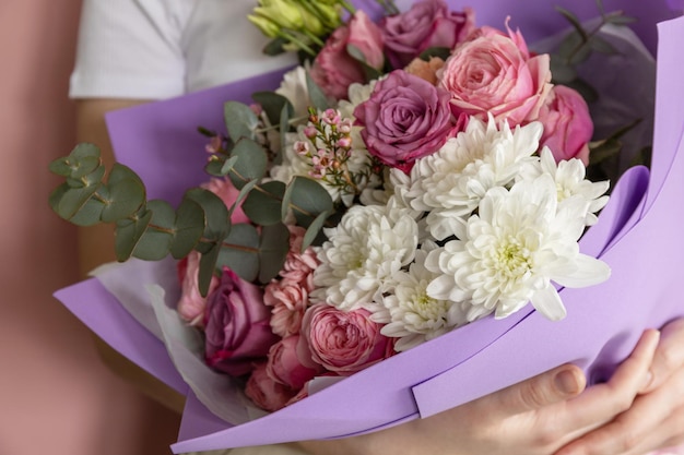 Les mains de la jeune fille très mignonne tiennent un beau bouquet de fleurs