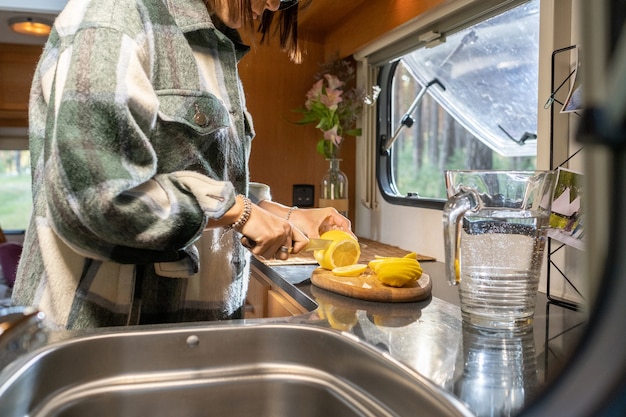 Mains de jeune voyageuse préparant la limonade