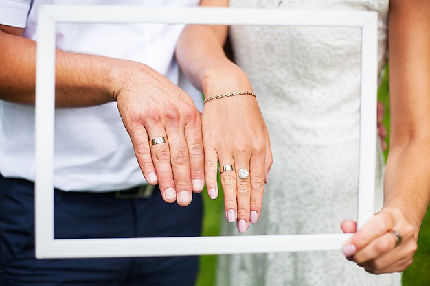 Les mains des jeunes mariés affichent leurs alliances