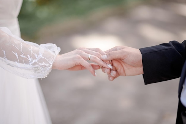 Mains de jeunes mariés libre Le marié tient les mains de la mariée couple d'amoureux se tenant la main tandis que w