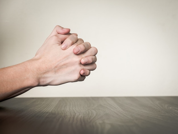 Mains jointes sur la table, concept de prière