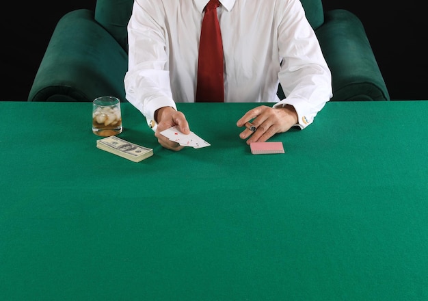 Photo les mains d'un joueur de poker sur une table de cartes vertes