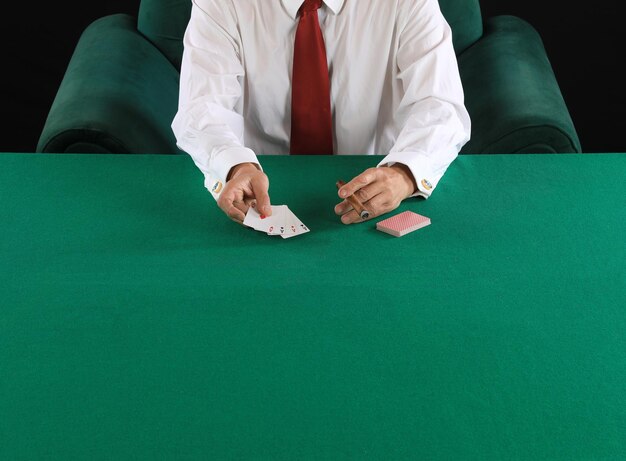 Photo les mains d'un joueur de poker sur une table de cartes vertes