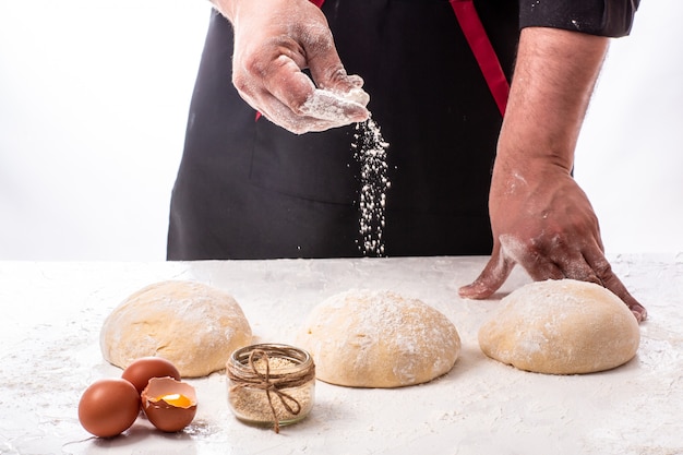 Mains mâles pétrir la pâte, close-up, faible profondeur de champ