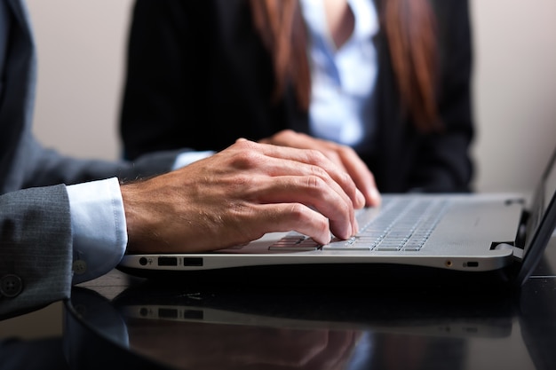 Mains mâles en tapant sur un clavier d&#39;ordinateur portable