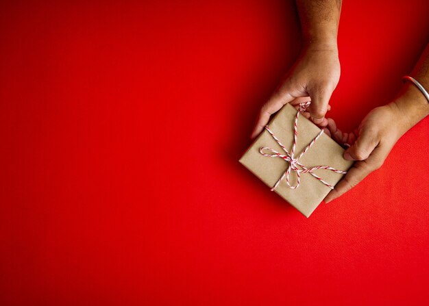 Mains mâles tenant une boîte cadeau rouge