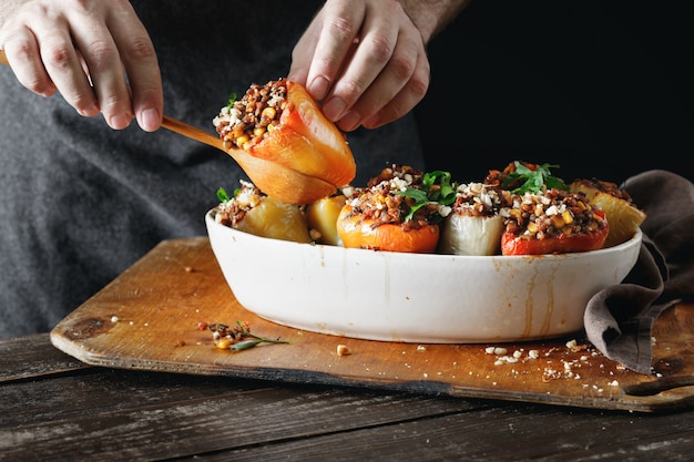 Mains mâles tenant des poivrons farcis cuits Nourriture végétarienne saine