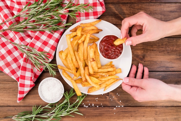 Mains mangeant de délicieuses frites