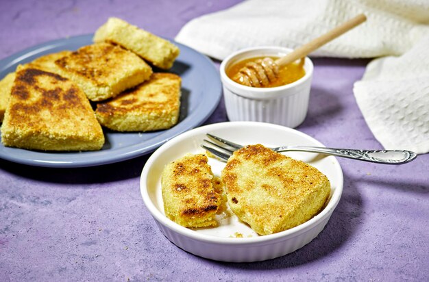 mains mangeant un harcha ou mbasses semolina crêpes algériennes sur une assiette colorée arabesque