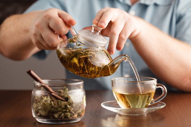 Mains de Mans et tasse en verre de tisane de médecine