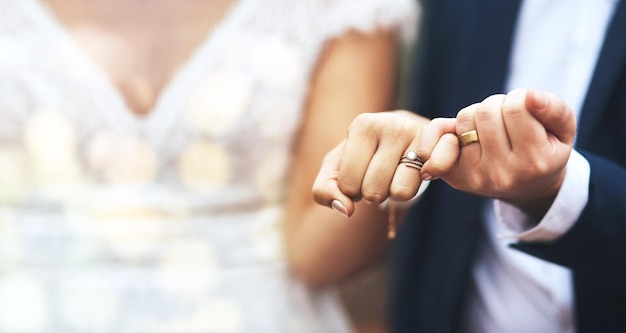 Mains marié et mariée avec des alliances dans une promesse rose d'engagement jurer ou vouer sur la maquette Main de couple marié amoureux partenariat ou confiance pour la fidélité ou l'accord de mariage