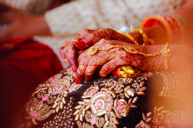 Mains de mariée décorées avec du bel art mehndi avec des bijoux et des bracelets colorés