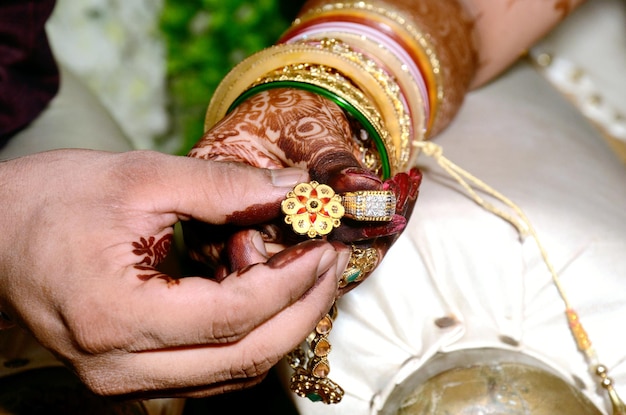 Les mains de la mariée et du marié tenant et montrant des bagues de bijoux de mariage